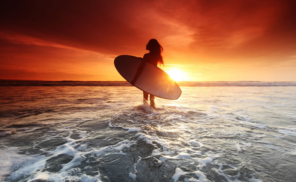 Surfer girl at sunset